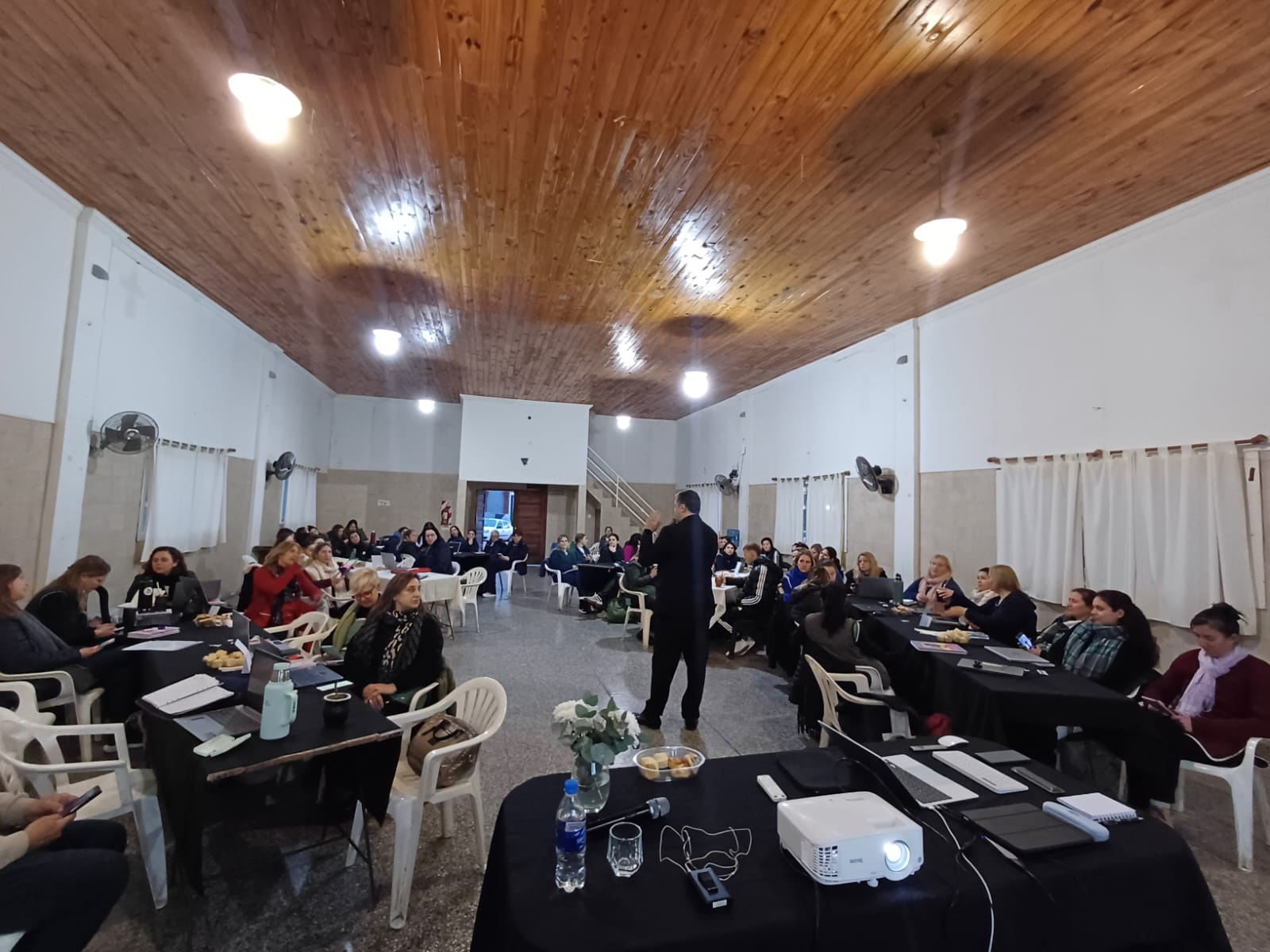 Vista general de un taller docente con mesas de trabajo y recursos digitales