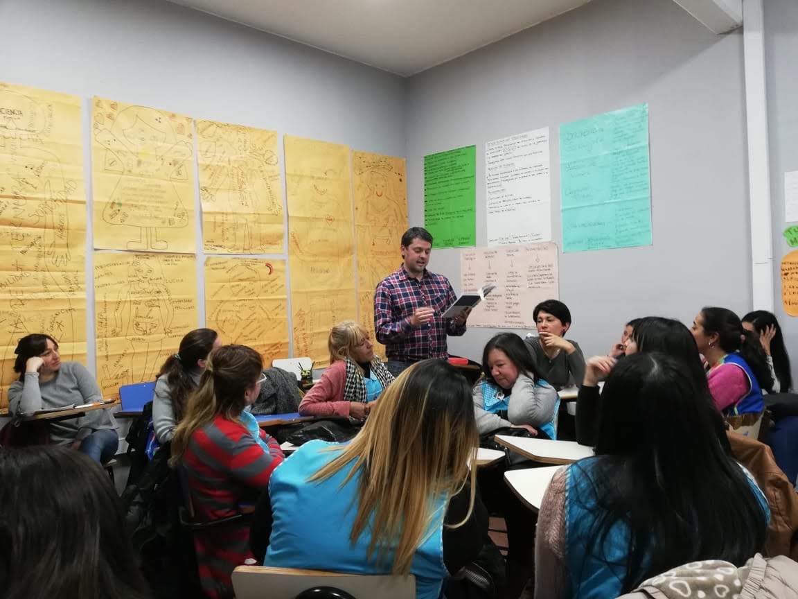 Taller con producciones en las paredes y profesionales trabajando de manera colaborativa